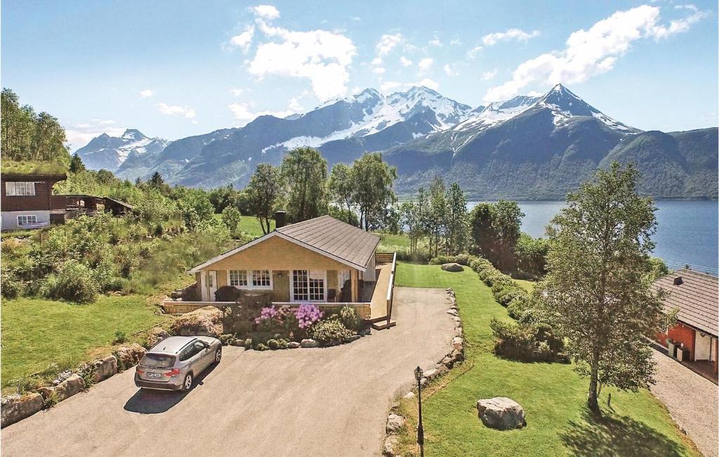 un'auto parcheggiata di fronte a una casa con le montagne di Gorgeous Home In Hundeidvik a Hundeidvik