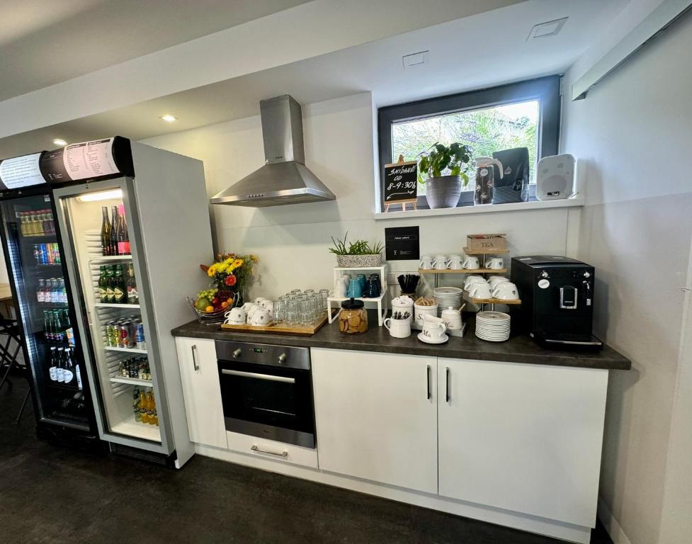 a kitchen with white cabinets and a refrigerator and a counter at Hotel Vincent in Luhačovice