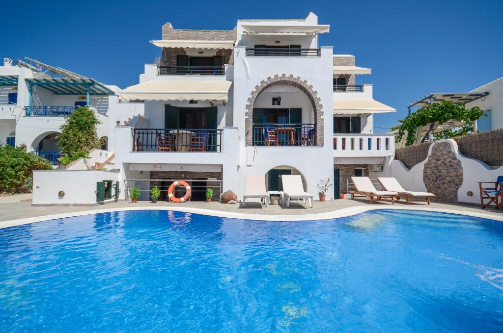 a villa with a swimming pool in front of a house at Orama Apartments in Agia Anna Naxos