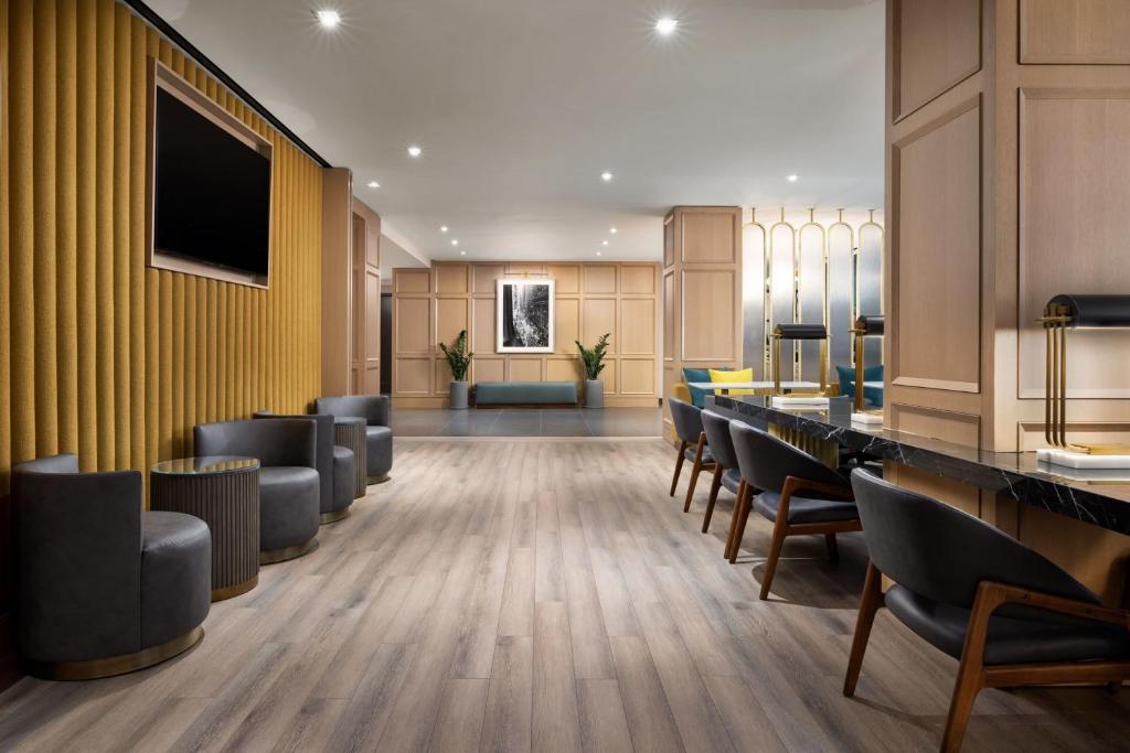 a lobby with a waiting room with chairs and a flat screen tv at Residence Inn by Marriott New York Downtown Manhattan/World Trade Center Area in New York