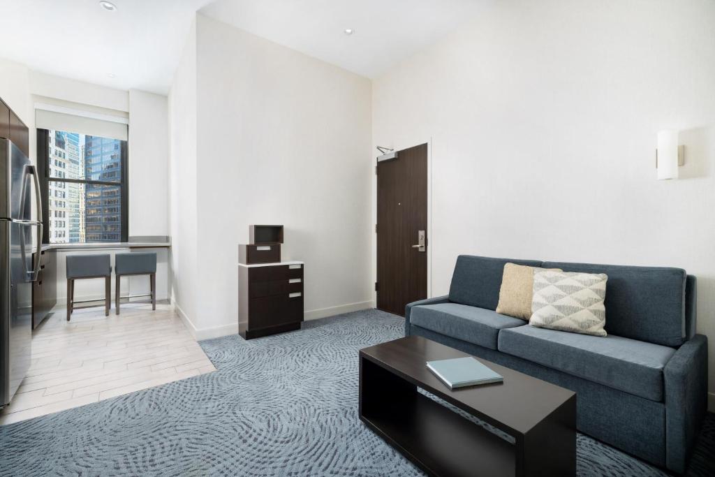 a living room with a blue couch and a table at Residence Inn by Marriott New York Downtown Manhattan/World Trade Center Area in New York