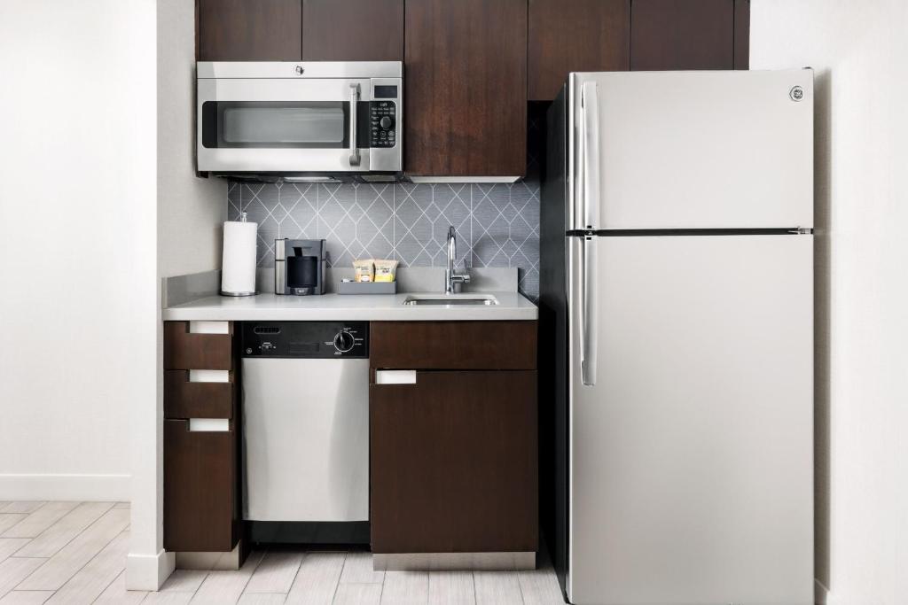 a kitchen with a white refrigerator and a microwave at Residence Inn by Marriott New York Downtown Manhattan/World Trade Center Area in New York