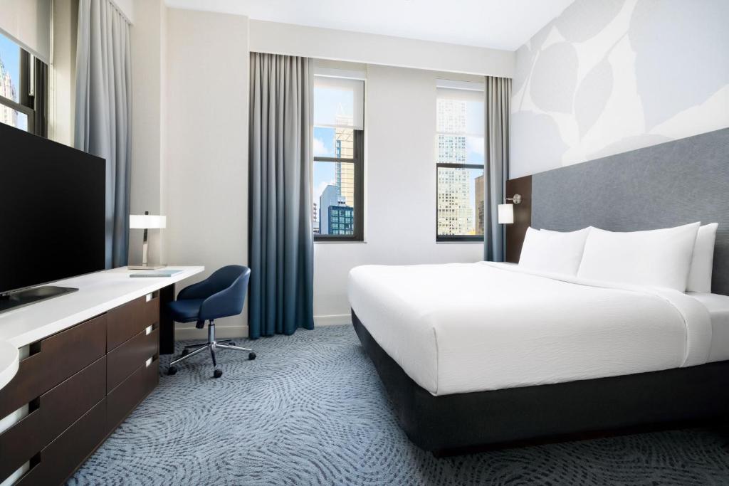 a hotel room with a bed and a desk and a tv at Residence Inn by Marriott New York Downtown Manhattan/World Trade Center Area in New York