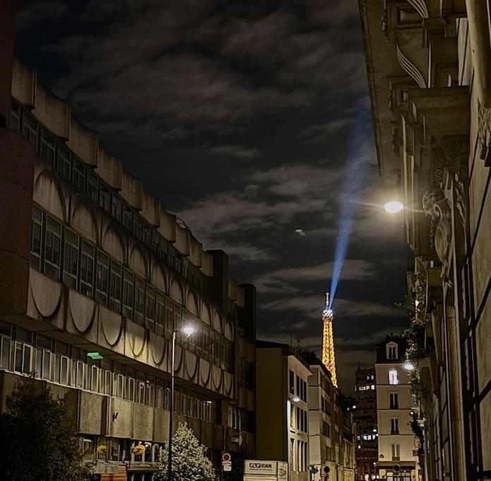une rue de la ville la nuit avec un bâtiment éclairé dans l'établissement Apartment near Eiffel Tower Olympic games tickets, à Paris