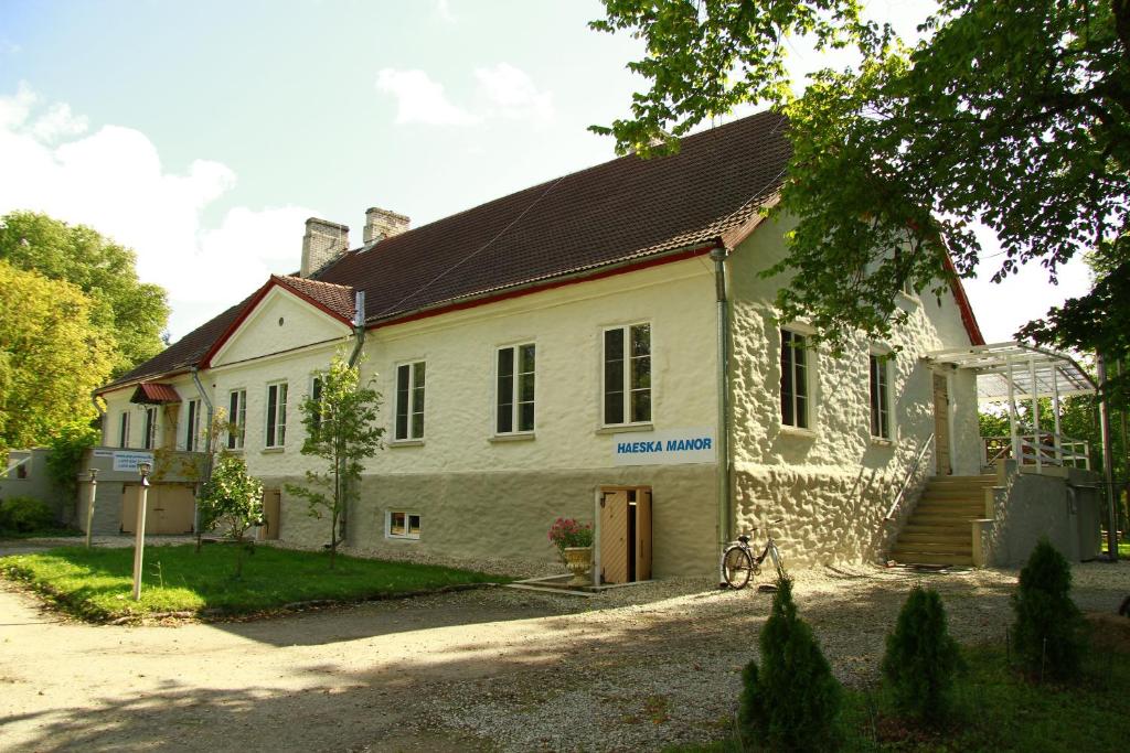 une maison blanche avec un toit marron dans l'établissement Haeska Manor, à Haeska