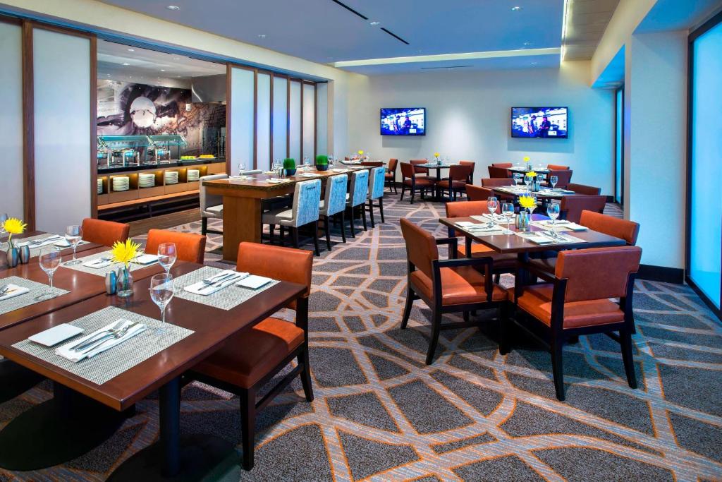 a restaurant with tables and chairs in a room at Newark Liberty International Airport Marriott in Newark