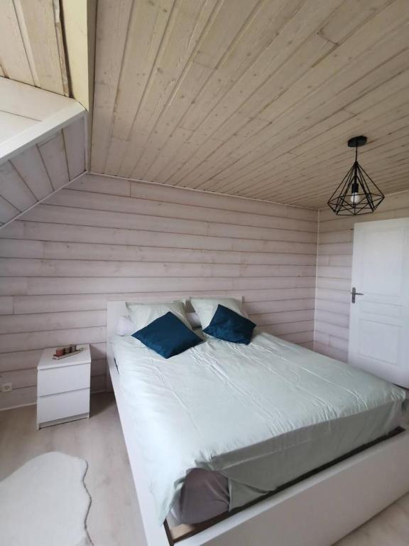 une chambre avec un lit blanc avec des oreillers bleus dans l'établissement El Dorado, à Genneville