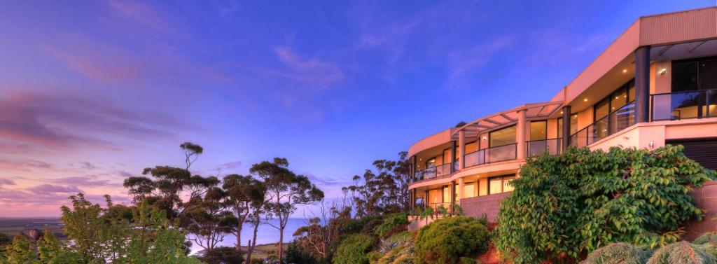 a building on the side of a hill at dusk at Sheer Pleasure Accommodation in Smithton