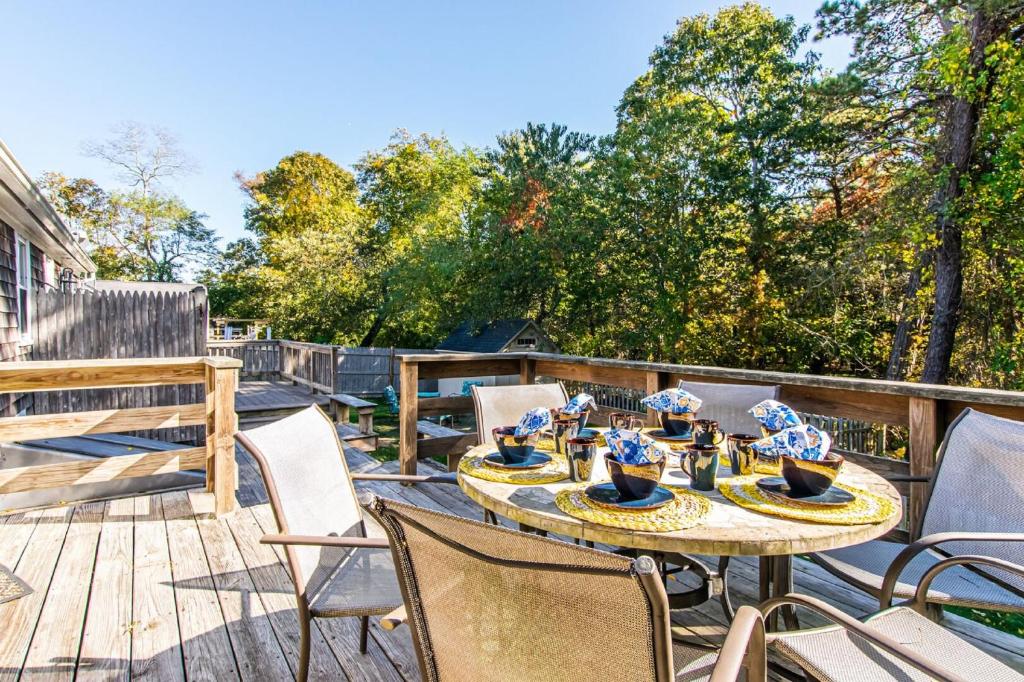 a patio with a table and chairs on a deck at Waterfront Cape Cod Home in Dennis Port
