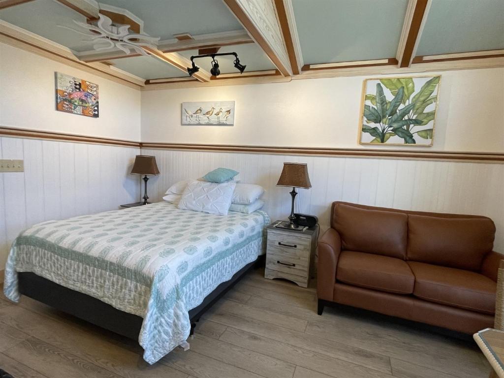 a bedroom with a bed and a chair at NC 12 56821-37 Condo in Hatteras