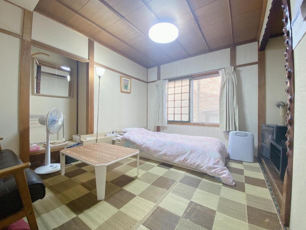 une chambre avec un lit et une table dedans dans l'établissement Ryokan Sansui, à Furano