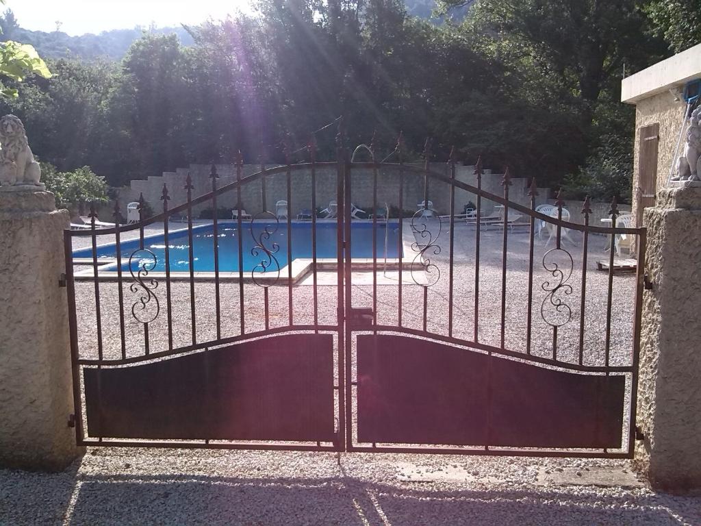 ein Eisentor mit einem Pool im Hintergrund in der Unterkunft Linda Gorges du Caramy in Tourves