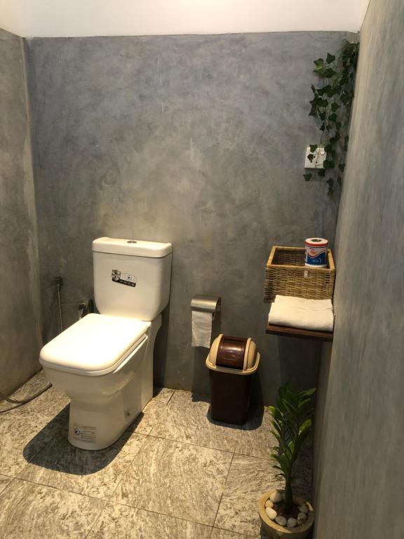 a bathroom with a white toilet and a plant at Villa D40 in Weligama