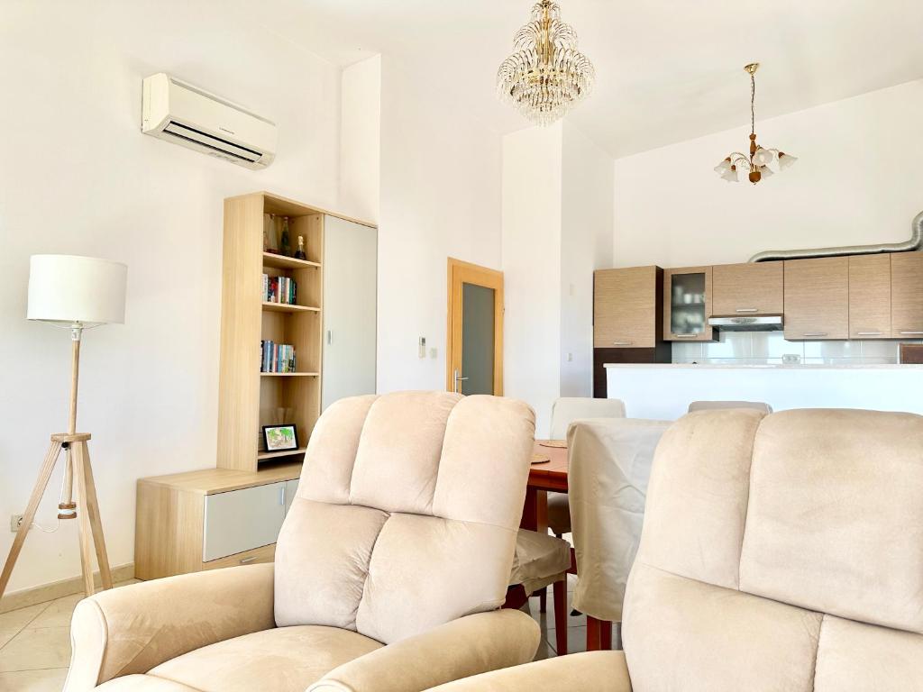 a living room with white chairs and a table at Apartment Elaine's View in Umag