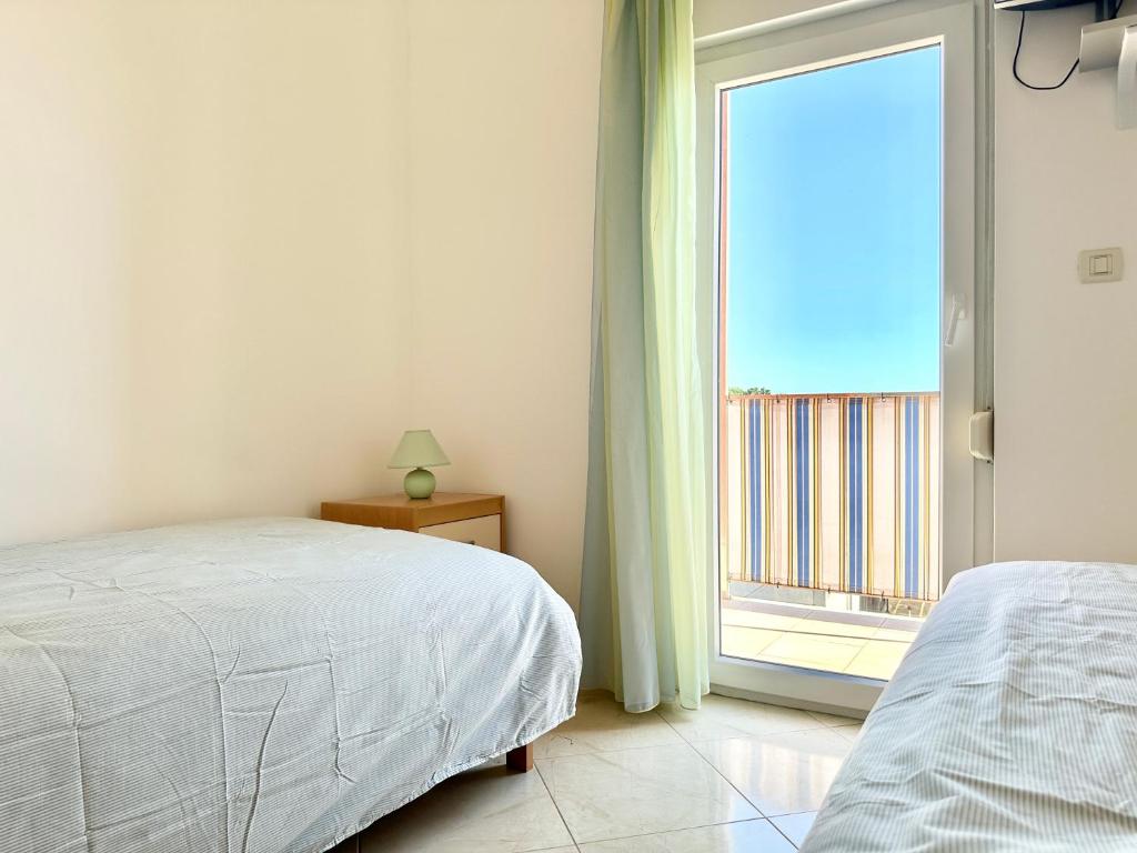 a bedroom with a bed and a large window at Apartment Elaine's View in Umag