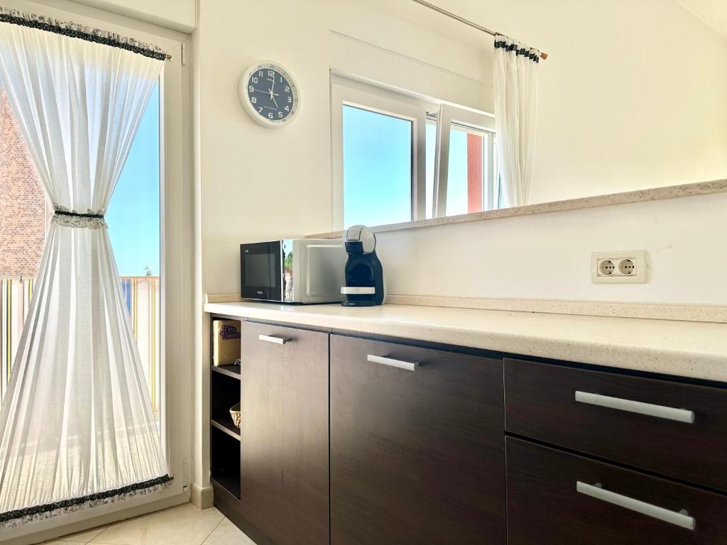a kitchen with a counter with a microwave and a window at Apartment Elaine's View in Umag