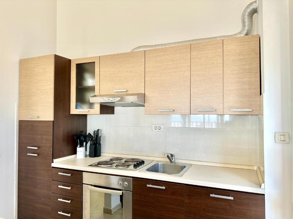 a kitchen with wooden cabinets and a sink at Apartment Elaine's View in Umag