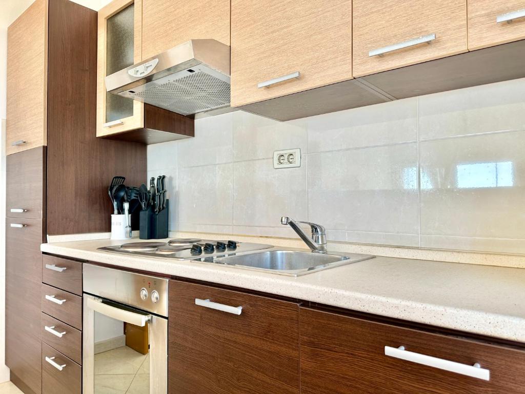 a kitchen with a sink and wooden cabinets at Apartment Elaine's View in Umag