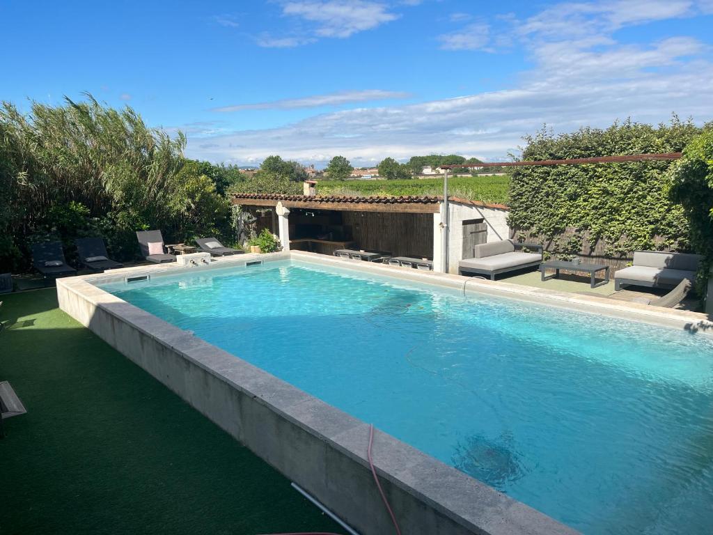 - une grande piscine dans une cour avec une terrasse dans l'établissement Gîte le Pressoir, à Narbonne