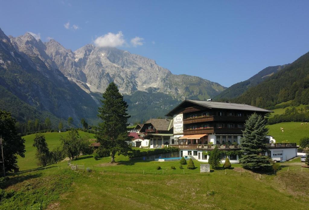 una casa en un campo con montañas al fondo en Pension Schöne Aussicht, en Kuchl