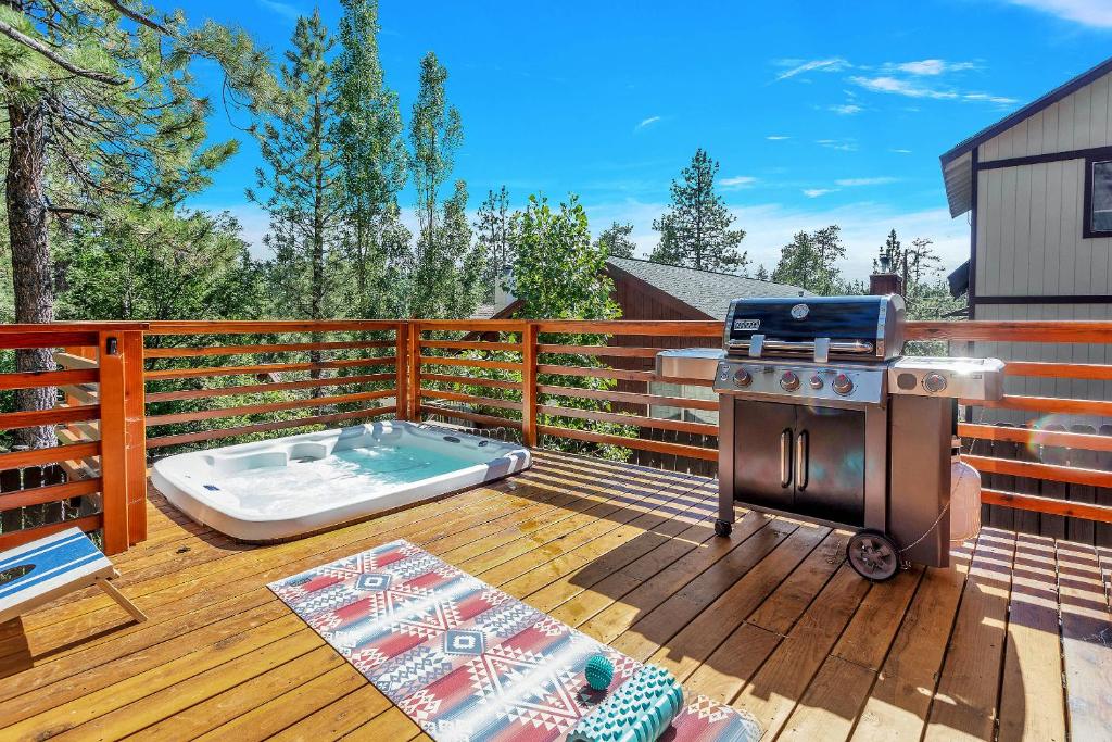 a patio with a grill and a hot tub on a deck at Sled-Ski Lakeside Village Cabin - Spa - BBQ - Firepit - Loft - Games in Big Bear Lake