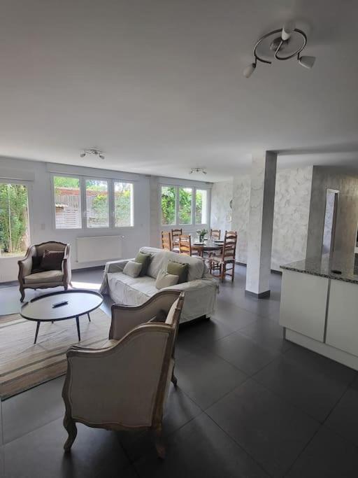 un salon avec des canapés, des chaises et une table dans l'établissement La campagne en ville, à Le Raincy