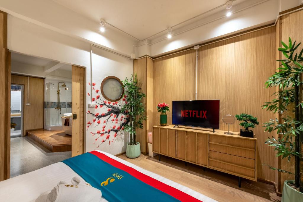 a bedroom with a bed and a tv on a wall at SHIN Hotel Chinatown in Khlong San