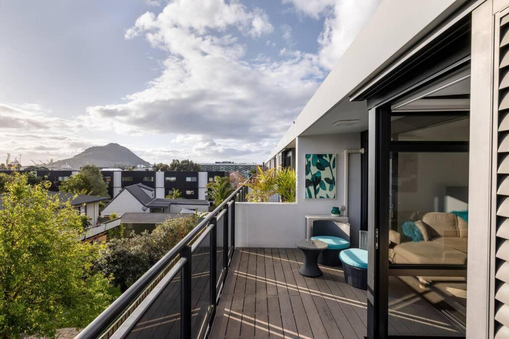 a balcony with a view of the mountains at The Lookout - Mount Maunganui in Mount Maunganui
