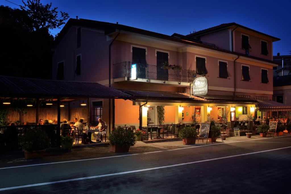 Ein Gebäude mit Leuten, die nachts draußen sitzen. in der Unterkunft Antica Locanda Luigina in Mattarana