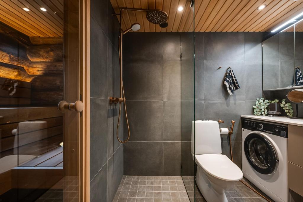 a bathroom with a toilet and a washing machine at Salmenkelo, Ruka in Ruka
