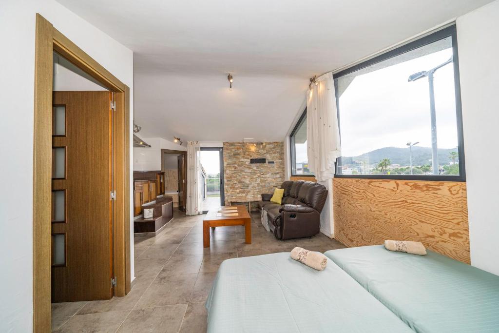 Un dormitorio con una cama, un sofá y una silla. en Casa Bohème, en Santa Susanna