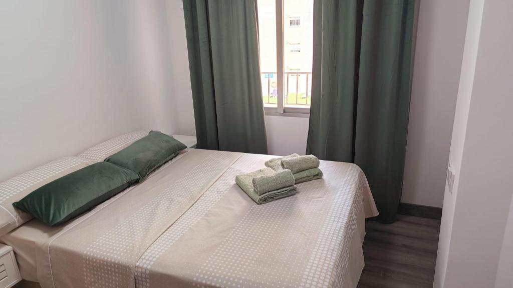 a bedroom with a bed with two pillows and a window at ALEJANDRO PLAYA Gandia 1 in Los Mártires