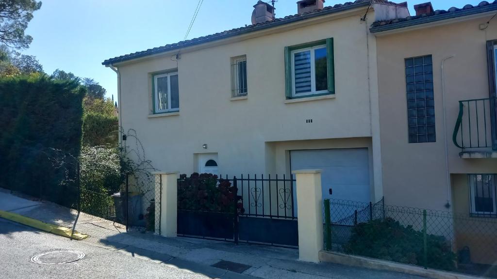 une maison blanche avec un portail et une clôture dans l'établissement Hébergement radieux, à Prades