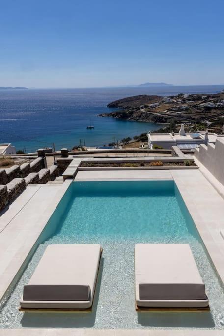 a swimming pool with two beds on top of a building at casa elysian in Agios Romanos