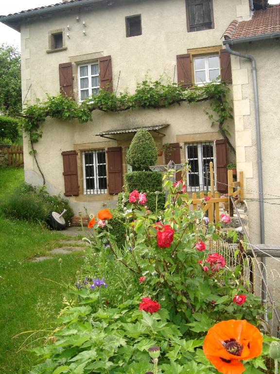 un jardin devant une maison avec des fleurs dans l'établissement maison de caractère rénovée, à Sainte-Colombe