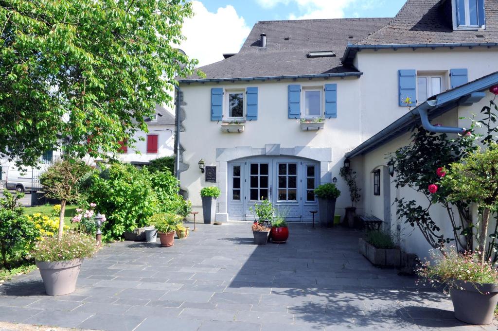a white house with potted plants in front of it at Maison CHILO in Barcus