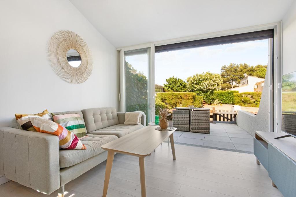 un salon avec un canapé et une table dans l'établissement Soho village, au Cap d'Agde