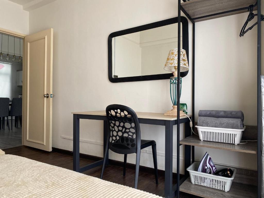 a bedroom with a desk with a chair and a mirror at Comfy 1 Bedroom Apartment in Melaka