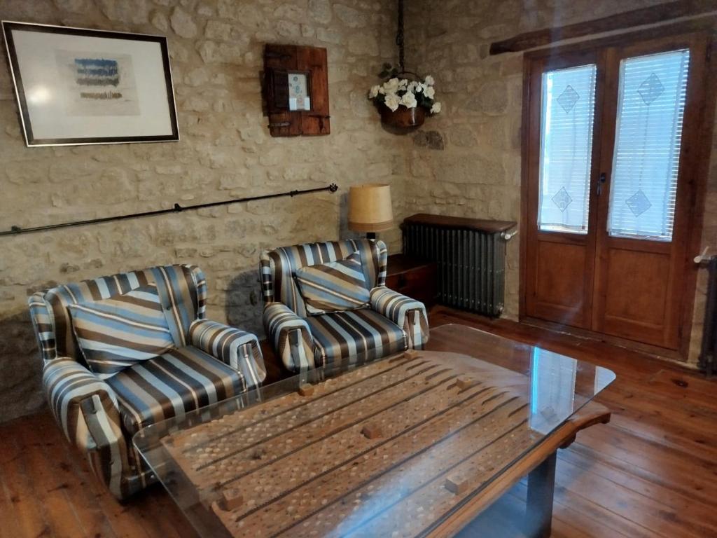 two chairs and a coffee table in a living room at El Desván del Campanero in Murillo de Gállego