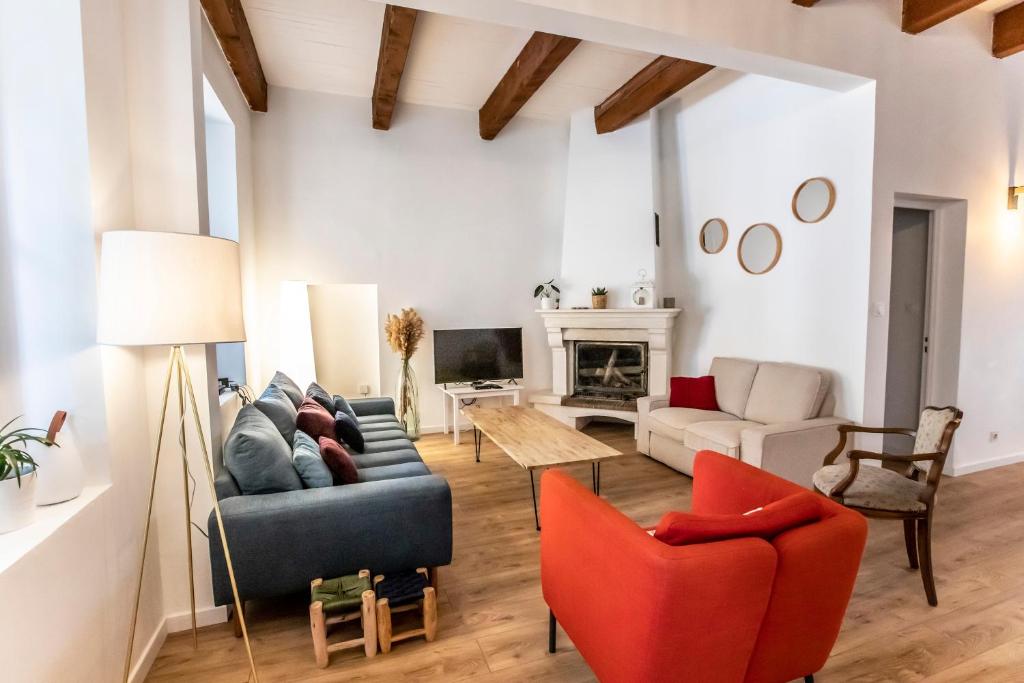 - un salon avec un canapé bleu et des fauteuils rouges dans l'établissement Maison familiale avec grand jardin, 2min de la mer, à Marseille