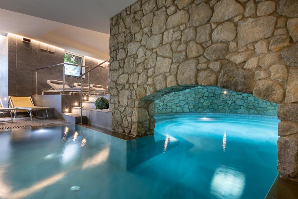 a swimming pool with a stone wall at Hotel Metropole in Santa Margherita Ligure
