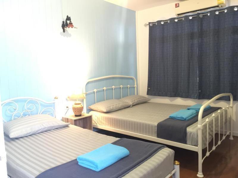 - deux lits dans une chambre bleue et blanche dans l'établissement Bann Chana BKK, à Bangkok