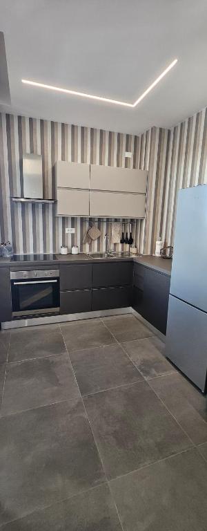 a large kitchen with a refrigerator and a stove at Forte2110 in Misano Adriatico