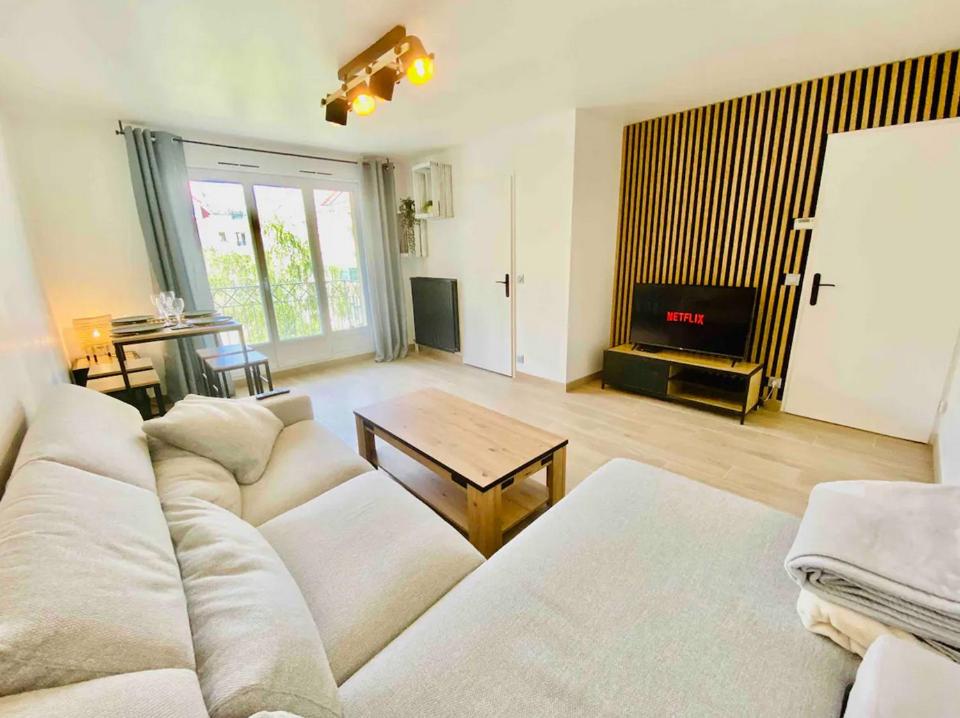 un salon avec un canapé blanc et une table dans l'établissement Superbe Appartement Poissy proche Gare / Stellantis, à Poissy