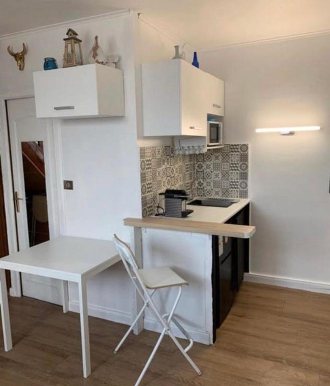 une petite cuisine avec une table et une chaise dans l'établissement Roch, à Fort-Mahon-Plage