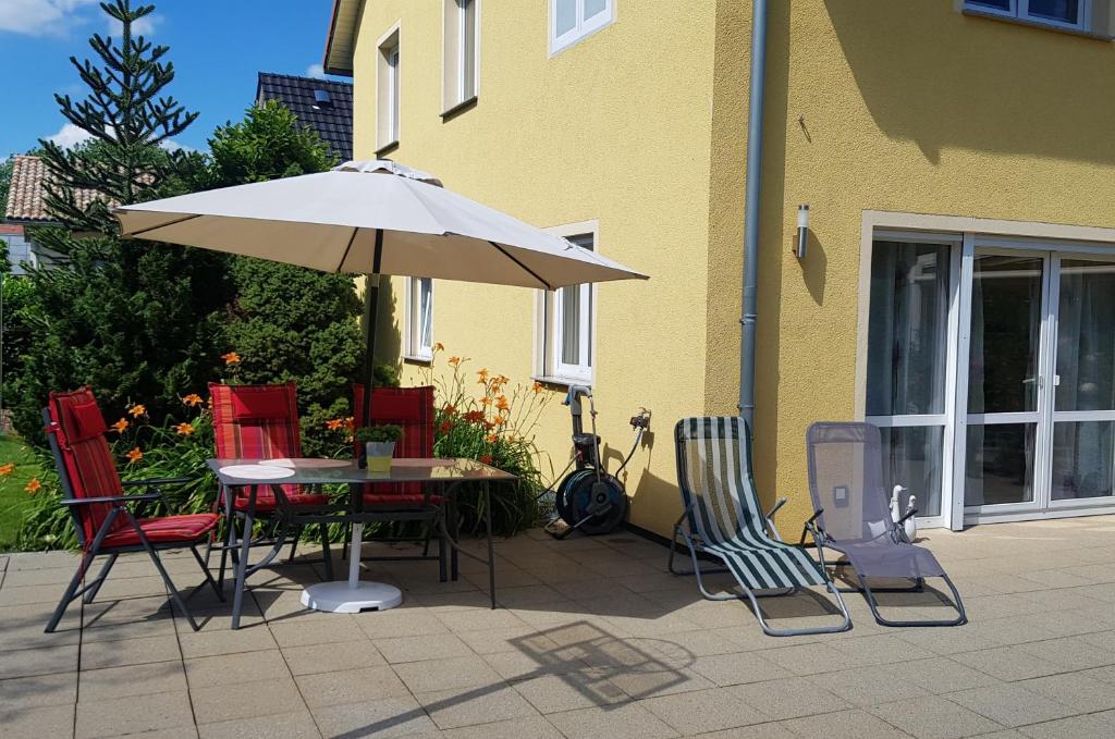 ein Tisch und Stühle mit einem Sonnenschirm neben einem Gebäude in der Unterkunft Oase im Dresdner Westen in Dresden