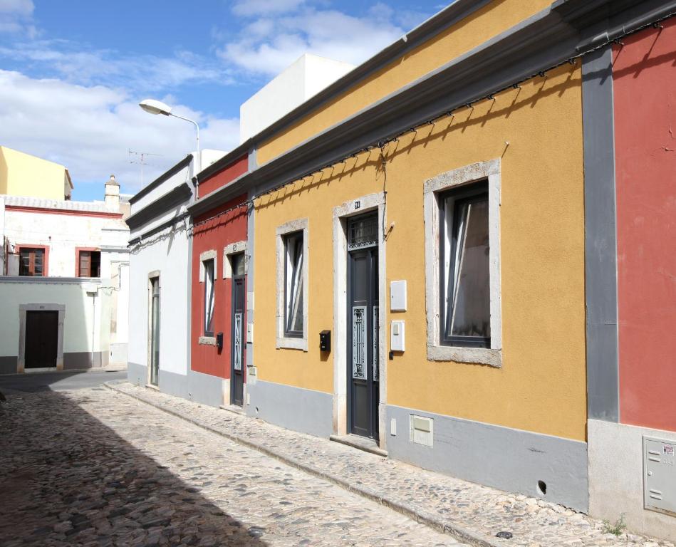 Casa da Viola - Faro في فارو: صف من المنازل الملونة على شارع
