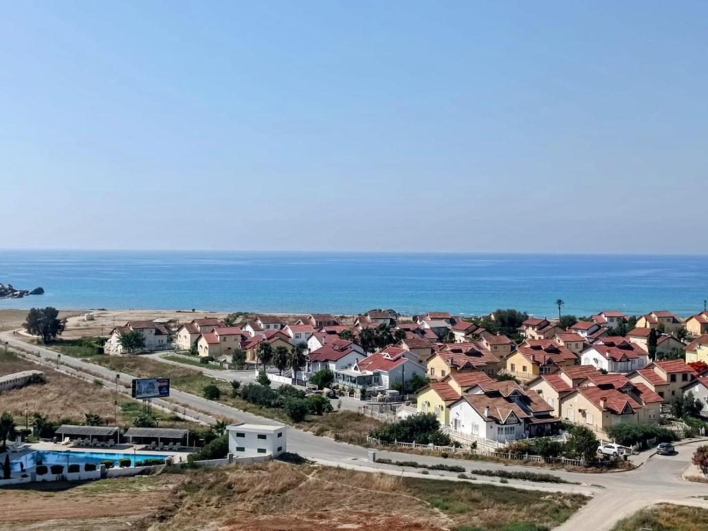 KalecikAzure Seaview Studio in Priscilla, Caesar Blue Resort & Spa, Gastria, Kalechik, Bogaz的鸟瞰小镇，房屋与海洋
