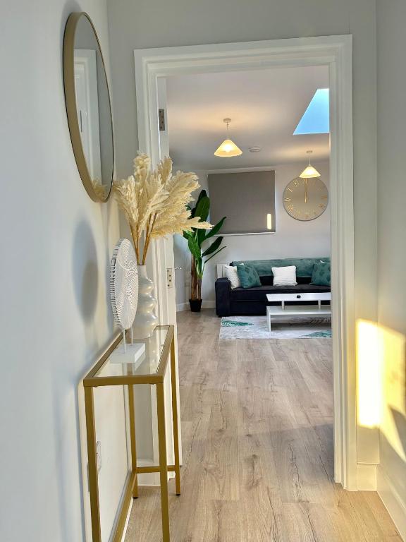 a living room with a couch and a table with a mirror at Folkestone Harbour 1 Bed Apartment F4 in Kent