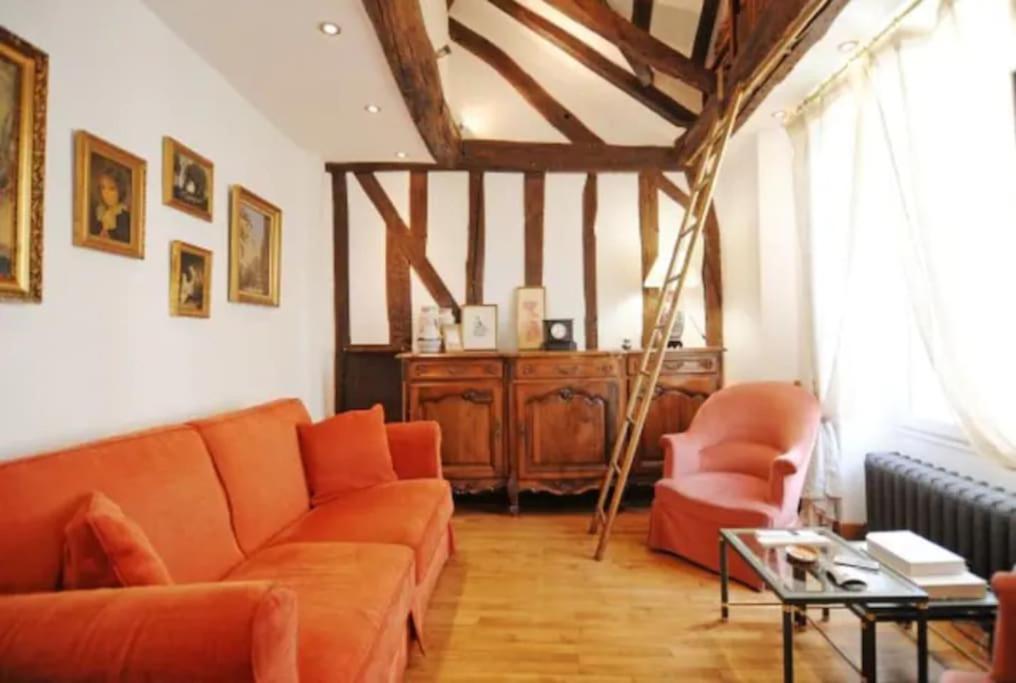 - un salon avec un canapé orange et une chaise dans l'établissement Duplex Paris proche du Panthéon, à Paris